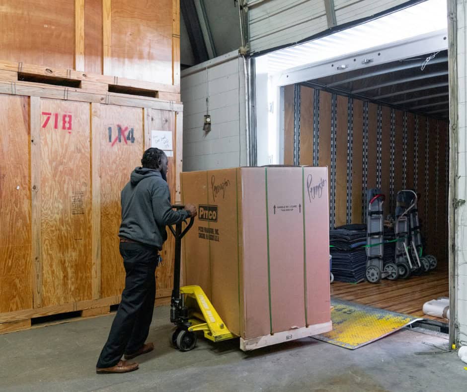a mover of fox moving and storage, moving a large box from storage facillity into the moving truck