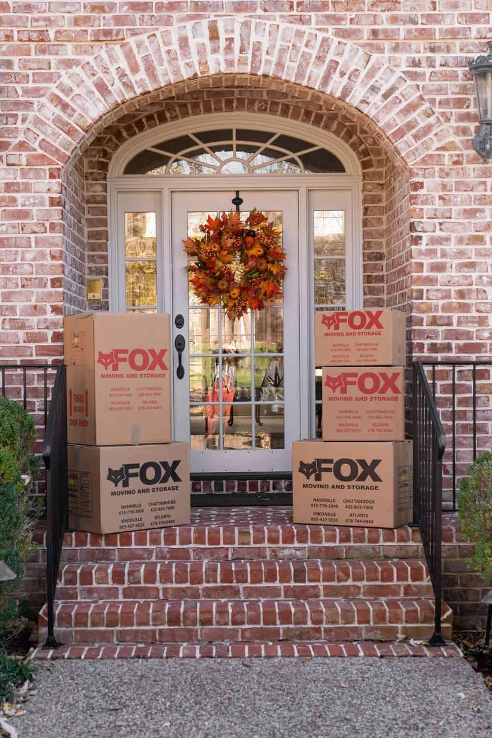 5 large moving boxes are placed in front of an old residential home