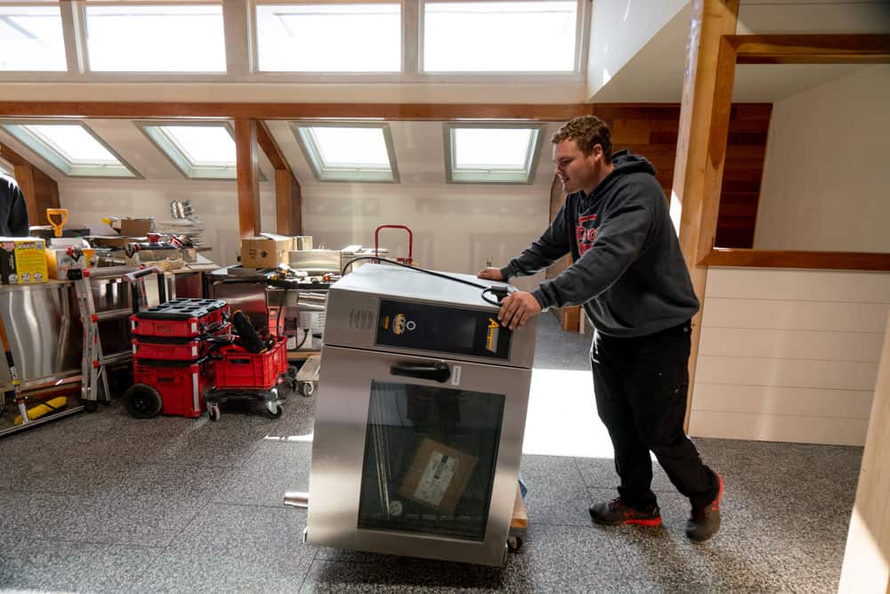 a large oven is being moved by a mover of fox moving and storage, in a residential property