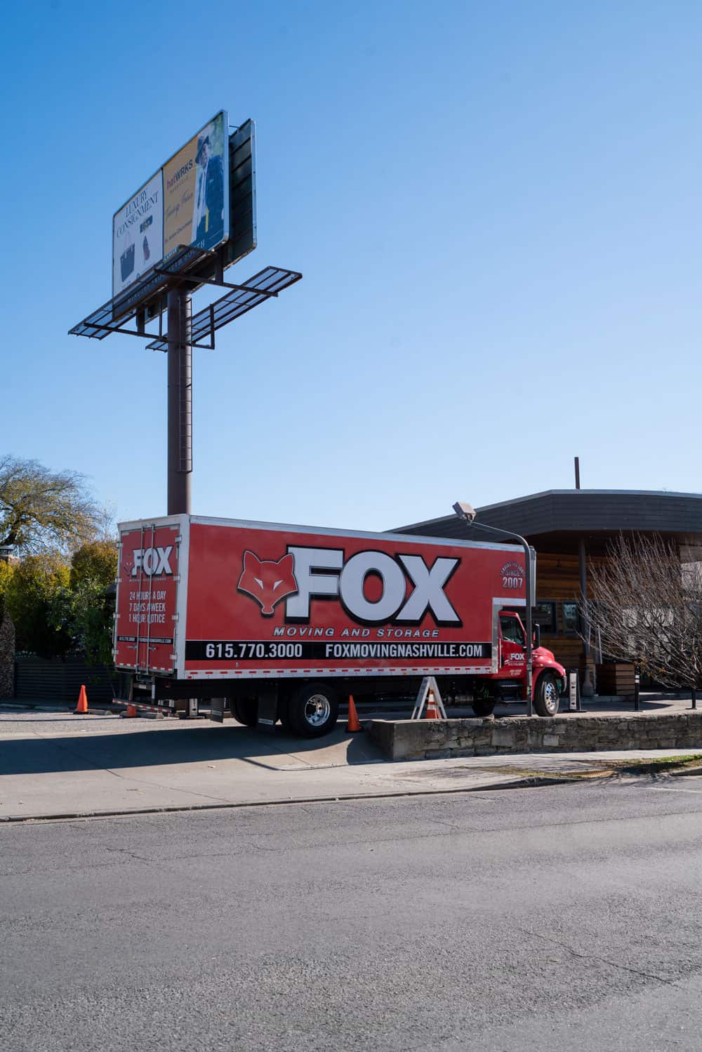 a nice image of the red moving truck of fox moving and storage standing outside of a commercial property being loaded