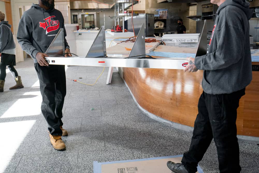 a pert of the commercial kitchen, is being moved out of the property by two movers of fox moving and storage
