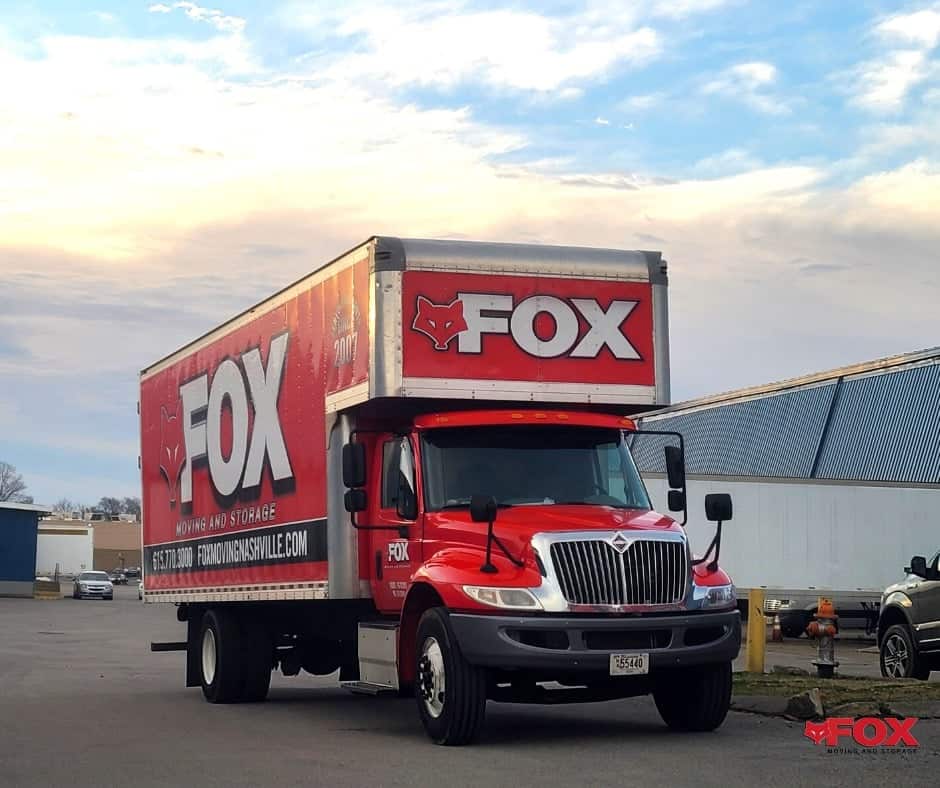 a nice picture of the red moving truck of Fox moving and storage standing in a parking lot