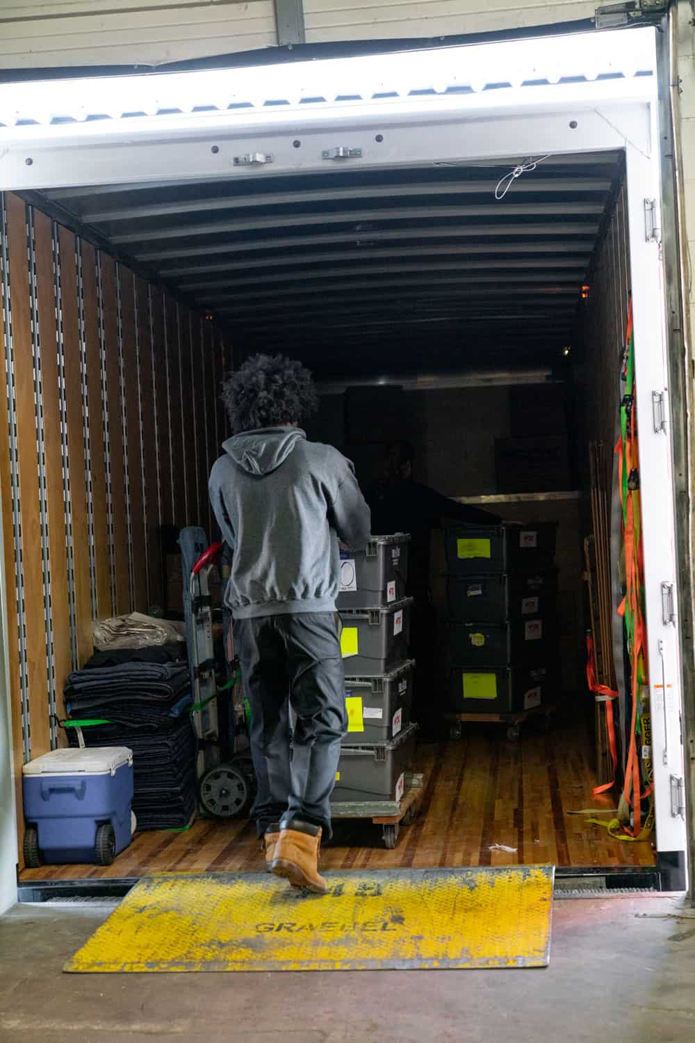 fox moving and storage's mover is loading several heavy duty boxes into the moving truck from the storage facility