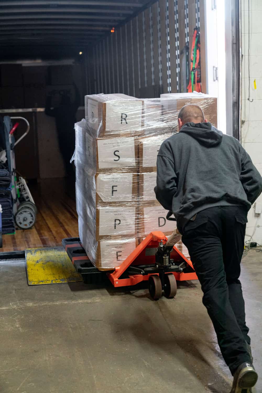several moving boxes, numbered with latin letters, are being loaded into a moving truck