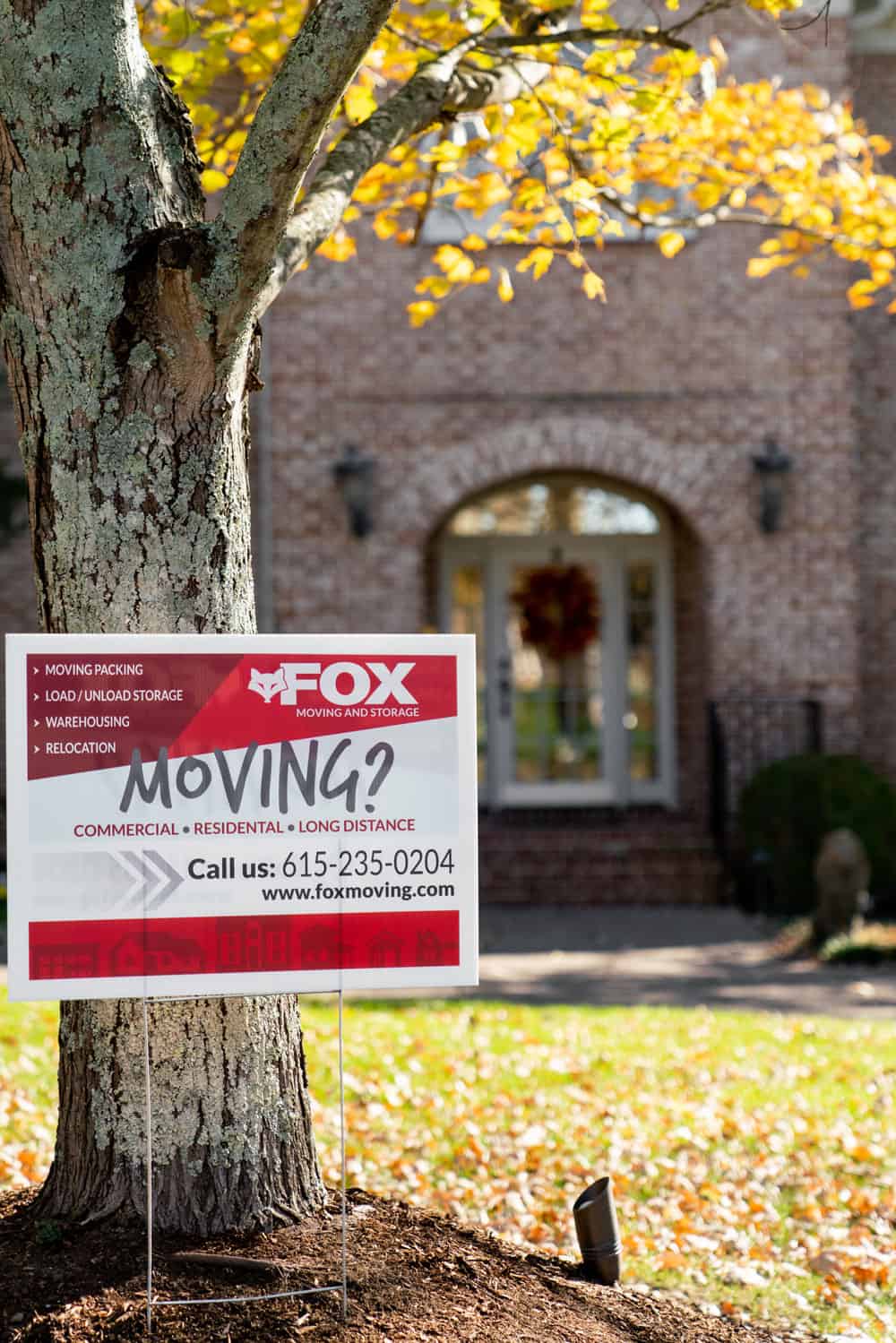 a banner is placed in front of a residential property, with the info to contact fox moving and storage